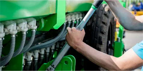 person fixing tractor